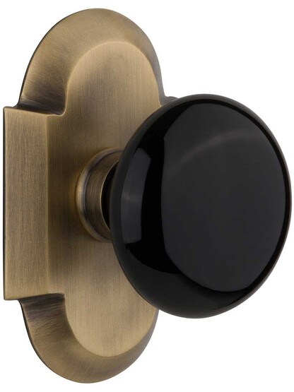 Arched Rosette Door Set with Black Porcelain Knobs in Antique Brass.
